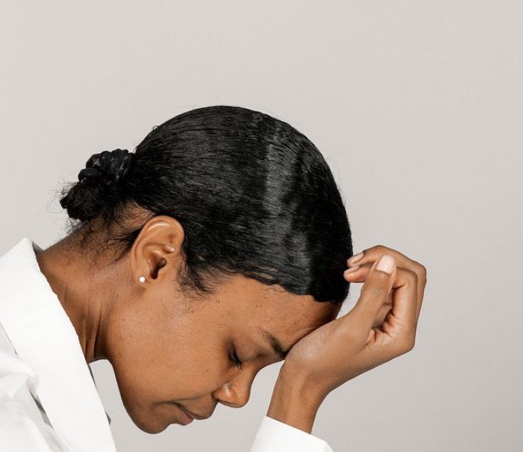 Unhappy black woman touching her head